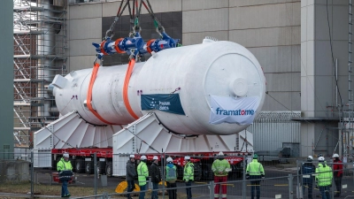 Ein Dampferzeuger wird mithilfe eines Schwerlastkrans aus dem Reaktorgebäude gehoben und auf zwei Träger für den Weitertransport montiert. (Foto: Daniel Vogl/dpa)