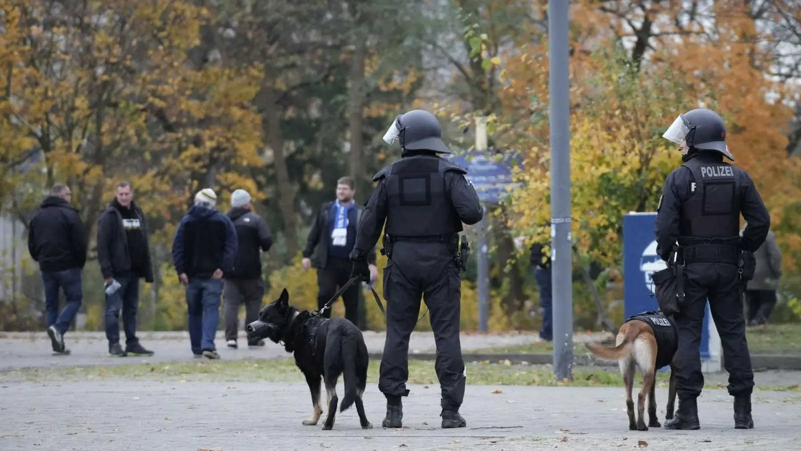 Fußballfans verließen das Olympiastadion nach dem Spiel der Hertha gegen Dynamo Dresden unter den kritischen Blicken etlicher Polizisten.  (Foto: Manuel Genolet/dpa)