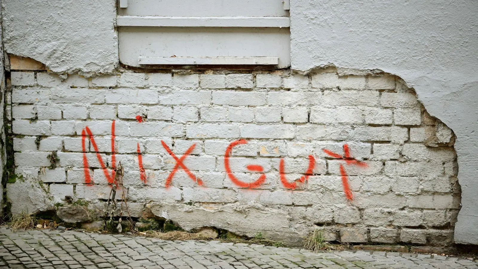 Der Schriftzug „Nix gut“ ist auf eine Fassade gesprüht, an der der Putz abgebröckelt ist. (Foto: Jan Woitas/dpa-Zentralbild/dpa-tmn)