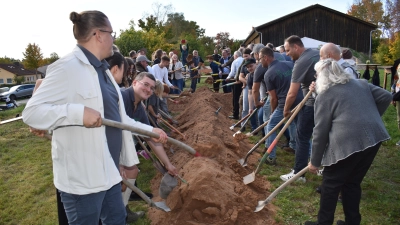 Mit vereinten Kräften wurde im Feuchtwanger Stadtteil Aichau gemeinsam der Spatenstich für die künftige Kapelle vollzogen. Der Sandhaufen war dazu in Kreuzform aufgeschüttet worden. (Foto: Erich Herrmann)