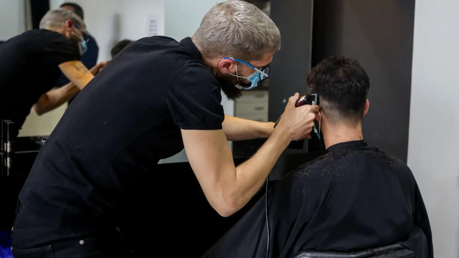 Ein Friseur schneidet die Haare eines Kunden in einem Friseursalon. (Foto: Ricardo Rubio/Europa Press/dpa)