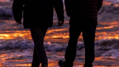 Spaziergänger sind nach Sonnenuntergang am Strand von Warnemünde an der Ostsee unterwegs. (Foto: Jens Büttner/dpa)