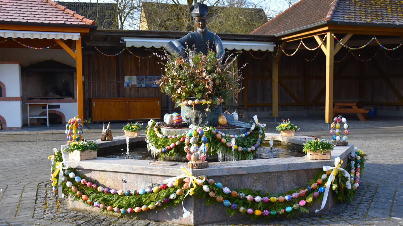 Der Pfarrer-Heumann-Brunnen auf dem Dorfplatz in Elbersroth ist wieder österlich geschmückt. Mitglieder des Dorfvereins haben hierfür rund 160 ausgeblasene Hühnereier bunt bemalt. Zusammen mit etwa 500 Exemplaren der vergangenen Jahre und mit Girlanden aus frischem Grün schmücken diese Kunstwerke in der Osterzeit den Brunnen. (Foto: Werner Wenk)