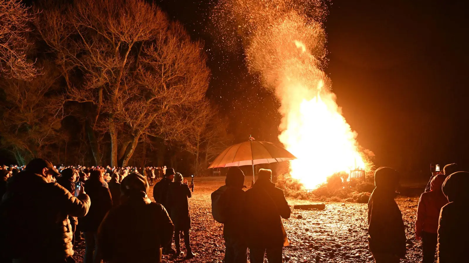Hunderte Besucher schauen sich das Funkenfeuer an, das am Abend am Ufer des Bodensees am Malereck angezündet wurde. (Foto: Felix Kästle/dpa)