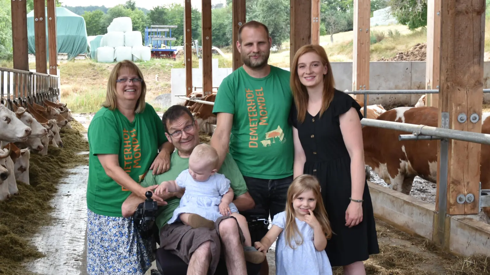 Familie Mondel im neu gebauten Kuhstall, von links Beate, Helmut und Hofbetreiber Simon Mondel, seine Frau Petra Schilling und vorne die dritte Generation Liora und Emelie. (Foto: Anita Dlugoß)