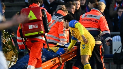 Paderborns Spieler Calvin Brackelmann wird nach einer Verletzung von Sanitätern auf einer Trage vom Spielfeld gebracht. (Foto: Gregor Fischer/dpa)