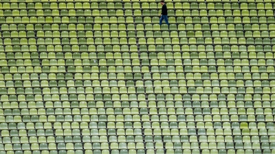 Zwischen leeren Rängen –  Ein Mann geht durchs Olympiastadion (Foto: Peter Kneffel/dpa)