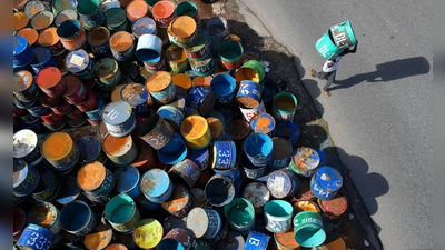 Fisch in bunten Dosen: Arbeiter im Bezirk Rangamati in Bangladesch tragen Metallfässer, die für den Transport von Fisch verwendet werden.  (Foto: Syed Mahabubul Kader/ZUMA Press Wire/dpa)