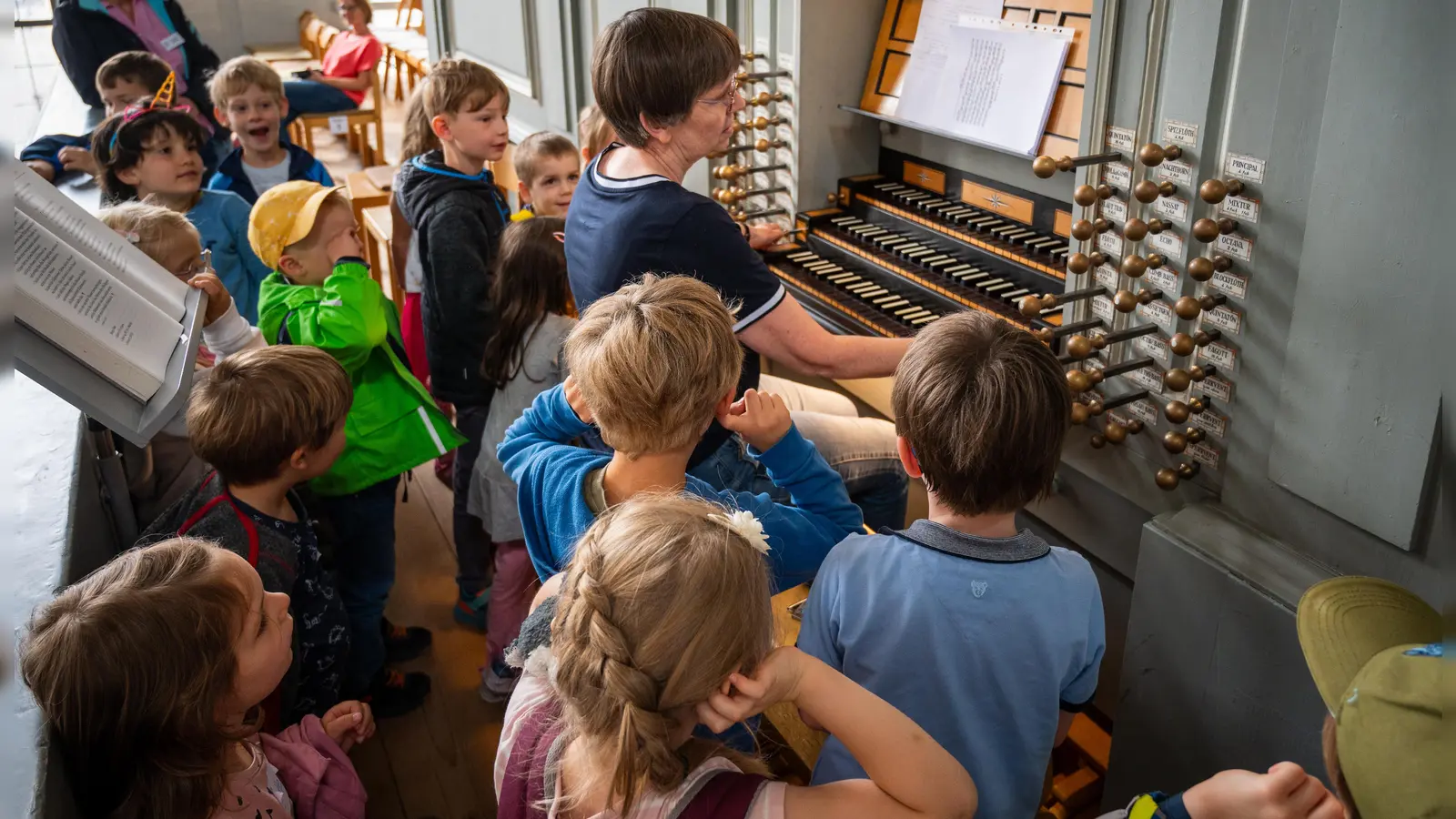 Workshop-Ausflug zur Wiegleb-Orgel von St. Gumbertus: Dekanatskantorin Ulrike Walch erläutert den Kindern das große Instrument, das ziemlich laut werden, aber auch sehr leise sein kann. (Foto: René Chlopotowski)