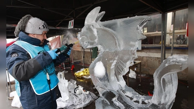 Weltcup im Eisskulpturenschnitzen: Ein Teilnehmer des Eisskulpturen Weltcup bearbeitet einen Eisblock mit einem Werkzeug. (Foto: Matthias Bein/dpa)