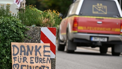 Ein Fahrzeug der Feuerwehr fährt an einem Schild mit der Aufschrift „Danke für Euren Einsatz” beim Waldbrand im Hürtgenwald vorbei.  (Foto: Federico Gambarini/dpa)