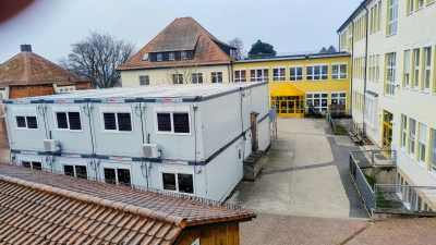 Die Grundschule an der Nürnberger Straße ist vor allem zwischen 1919 und 1964 entstanden. Die Container im Pausenhof belegen, dass sie längst zu klein ist. Kommt statt der geplanten Erweiterung ein kompletter Neubau?  (Foto: Eckard Dürr)
