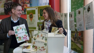 Gemeinsam für weniger Lebensmittelabfälle: Landrat Jürgen Ludwig und Lena Navarro Ortiz zeigen die „Beste-Reste“-Ausstellung und den neuen Kalender im Landratsamt Ansbach. (Foto: Landratsamt Ansbach/Fabian Hähnlein)