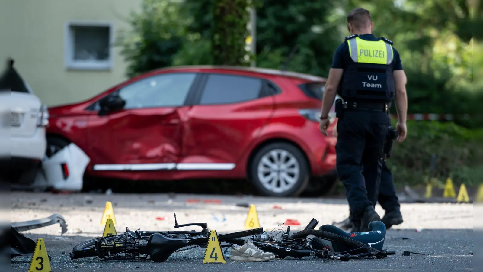 Ein zerstörtes Fahrrad, ein verlorener Schuh auf der Fahrbahn - eine Frau hat drei Kinder angefahren. (Foto: Fabian Strauch/dpa)