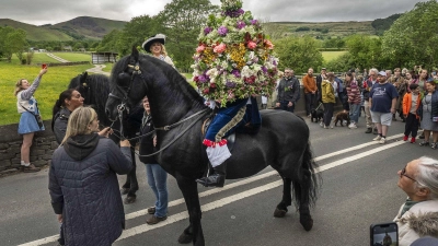 Blütenpracht im Sattel: Castleton krönt seinen Girlandenkönig (Foto: Danny Lawson/PA Wire/dpa)