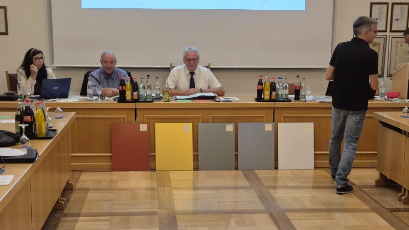 Sichtlich gut gelaunt wartete das Bürgermeister-Trio mit Heike Gareis, Peter Holzmann und Klaus Meier (sitzend von links) auf das Ergebnis der Abstimmung über die am Ratstisch lehnenden Musterplatten, nachdem Bauamtsleiter Gerald Schorr (rechts) die Stimmzettel verteilt hatte.  (Foto: Patrick Lauer)