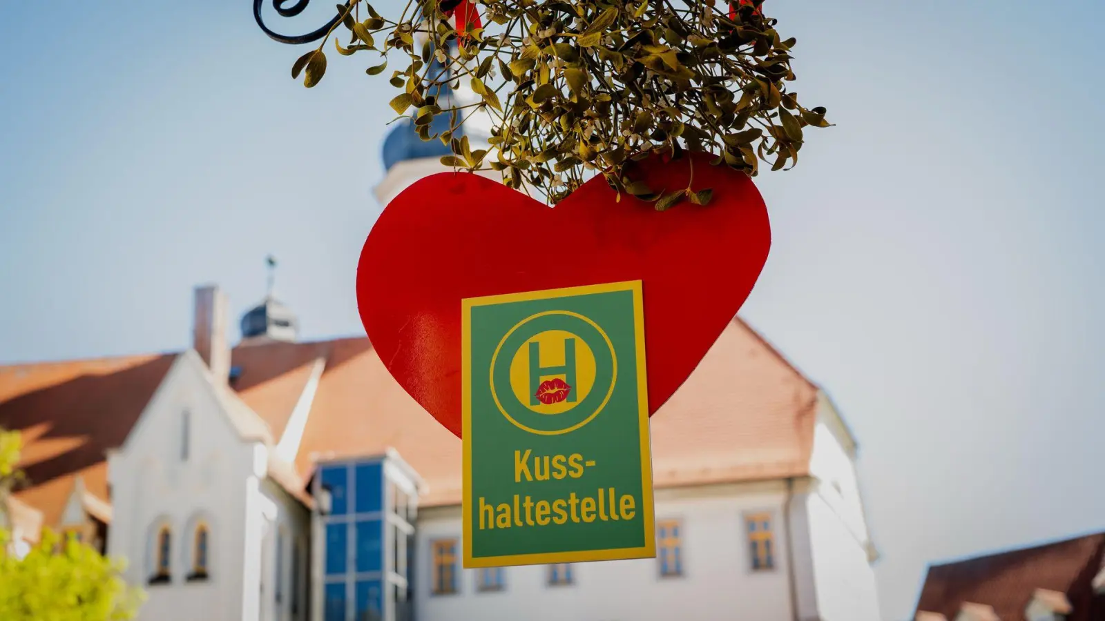 Rotes Herz und Mistelzweig: Auf dem Marktplatz in Eisenberg ist Küssen ausdrücklich erwünscht. (Foto: Jacob Schröter/dpa)