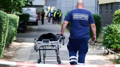 Ein Mann von der Gerichtsmedizin schiebt eine Bahre in der Nähe des Fundortes des toten Neugeborenen. (Foto: Annette Riedl/dpa)