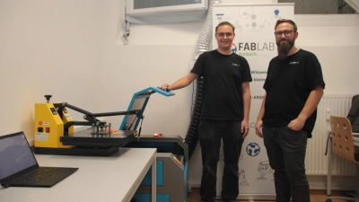 Kilian Kreibich (li.) und Lukas Dietz freuen sich über die Möglichkeiten, die ihnen ihre erste eigene FabLab-Werkstatt bietet. Besonders stolz sind sie auf den Lasercutter, neben dem sie stehen. (Foto: Robert Maurer)