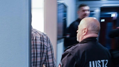 Ein Justizbeamter begleitet den Angeklagten in den Gerichtssaal. (Foto: Rabea Gruber/dpa)