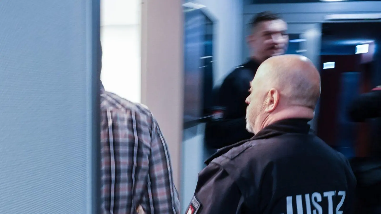 Ein Justizbeamter begleitet den Angeklagten in den Gerichtssaal. (Foto: Rabea Gruber/dpa)