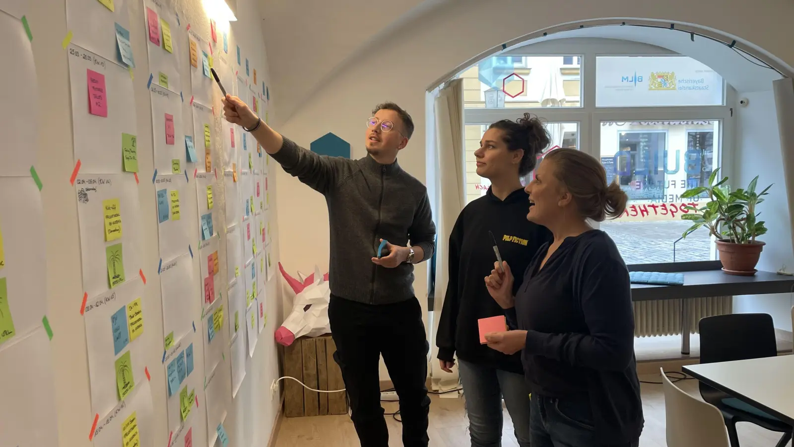 Werkstudent Marius Herzig, Praktikantin Michaela Hofherr und Standortleiterin Svenja Weiß (von links) besprechen die Jahresplanung des Media Lab in Ansbach. (Foto: Anna Beigel)