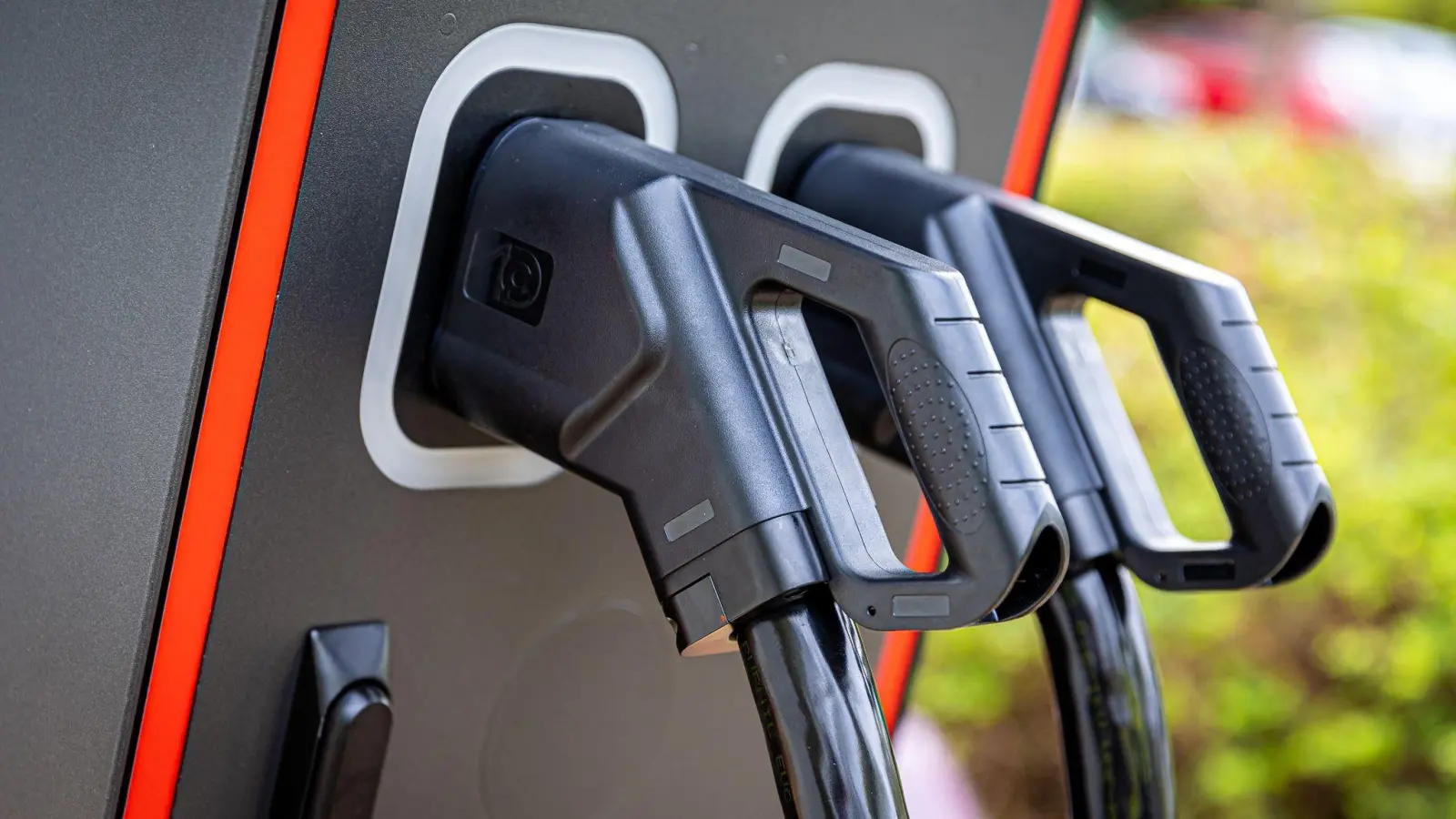 Zwei Ladekabel in einer Ladesäule für Elektroautos: Bei Dinkelsbühl ist eine „Grüne Tankstelle” an der A7 angedacht. (Symbolbild: Moritz Frankenberg/dpa)