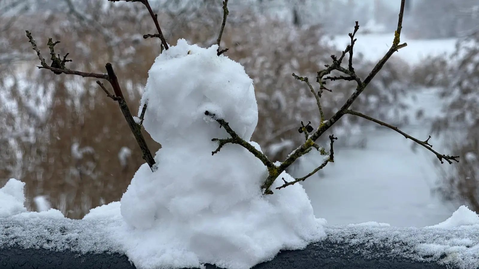Der vermutlich kleinste Schneemann der Region steht auf dem Geländer der Entenbrücke im Bürgerpark an der Ansbacher Rezat.  (Foto: Manfred Blendinger)