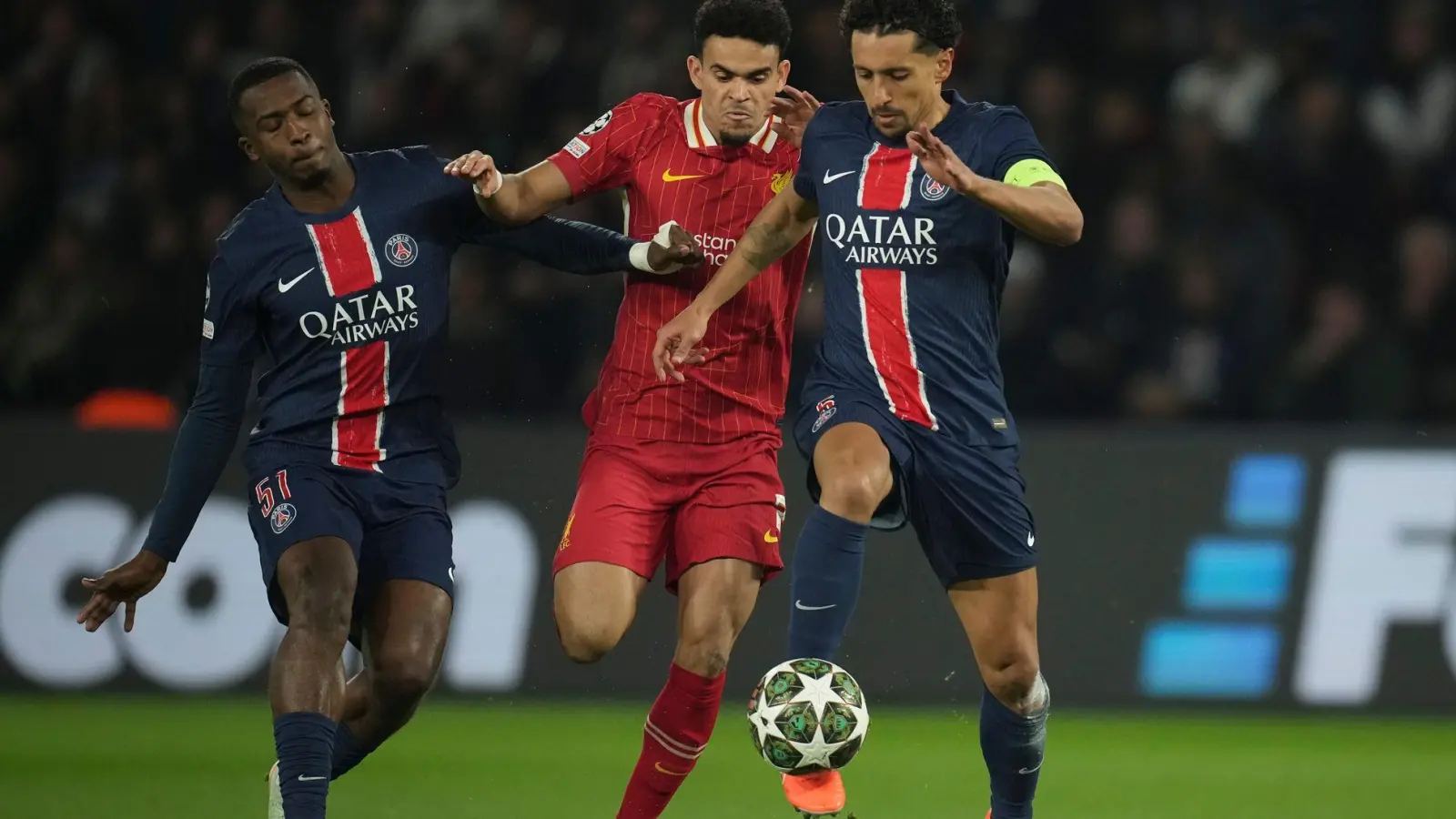 Nicht nur Liverpools Luis Diaz (M) hatte gegen die Pariser Willian Pacho (l) und Marquinhos mächtig Probleme.   (Foto: Christophe Ena/AP/dpa)