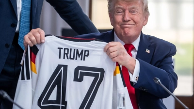 Trump zeigt sein Geschenk zum 80. Geburtstag.  (Foto: Michael Kappeler/dpa-Pool/dpa)