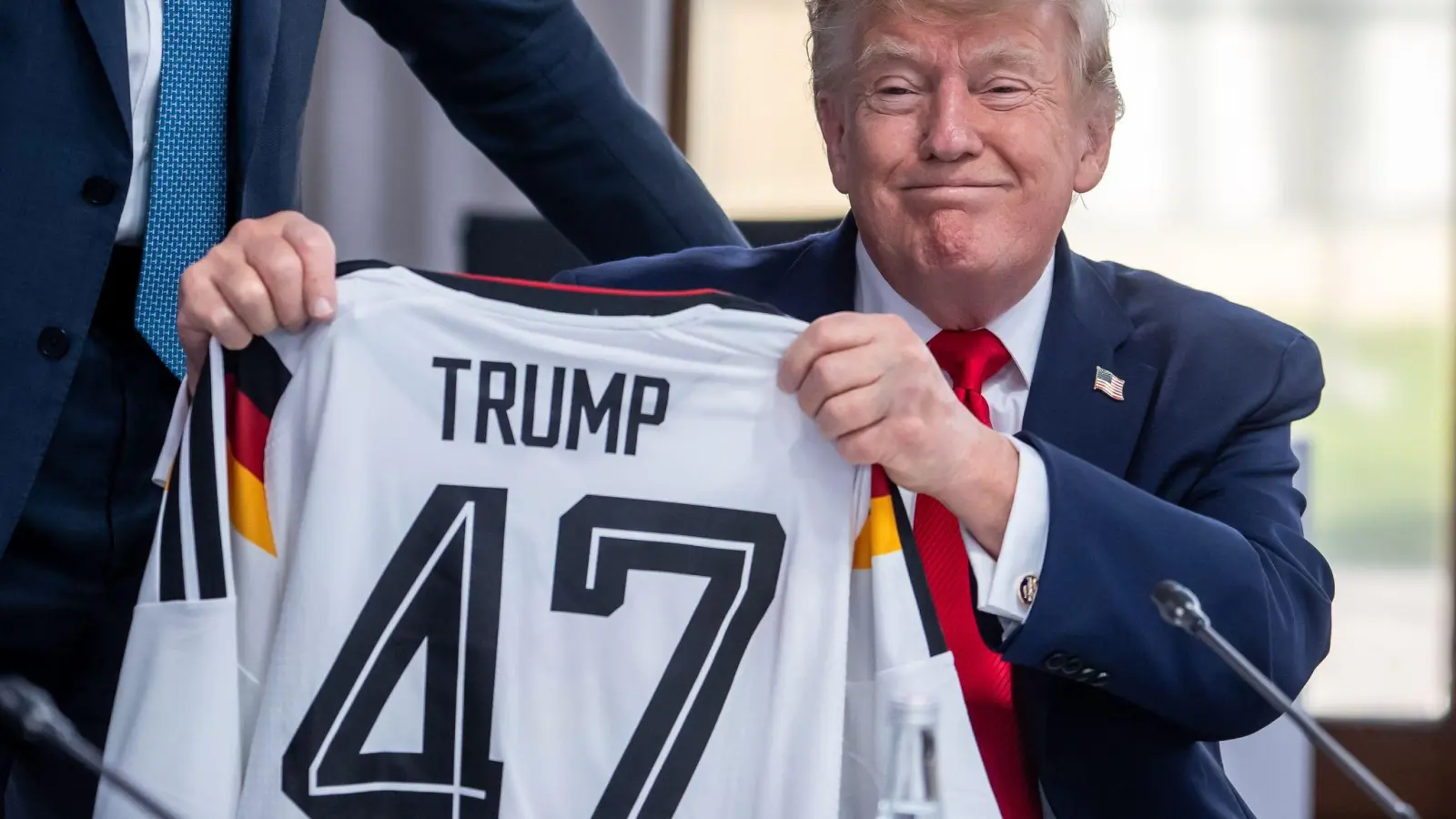 Trump zeigt sein Geschenk zum 80. Geburtstag.  (Foto: Michael Kappeler/dpa-Pool/dpa)