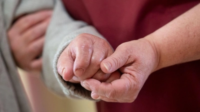 Eine Pflegekraft betreut in einem Seniorenhaus einen Bewohner. (Foto: Marijan Murat/dpa)