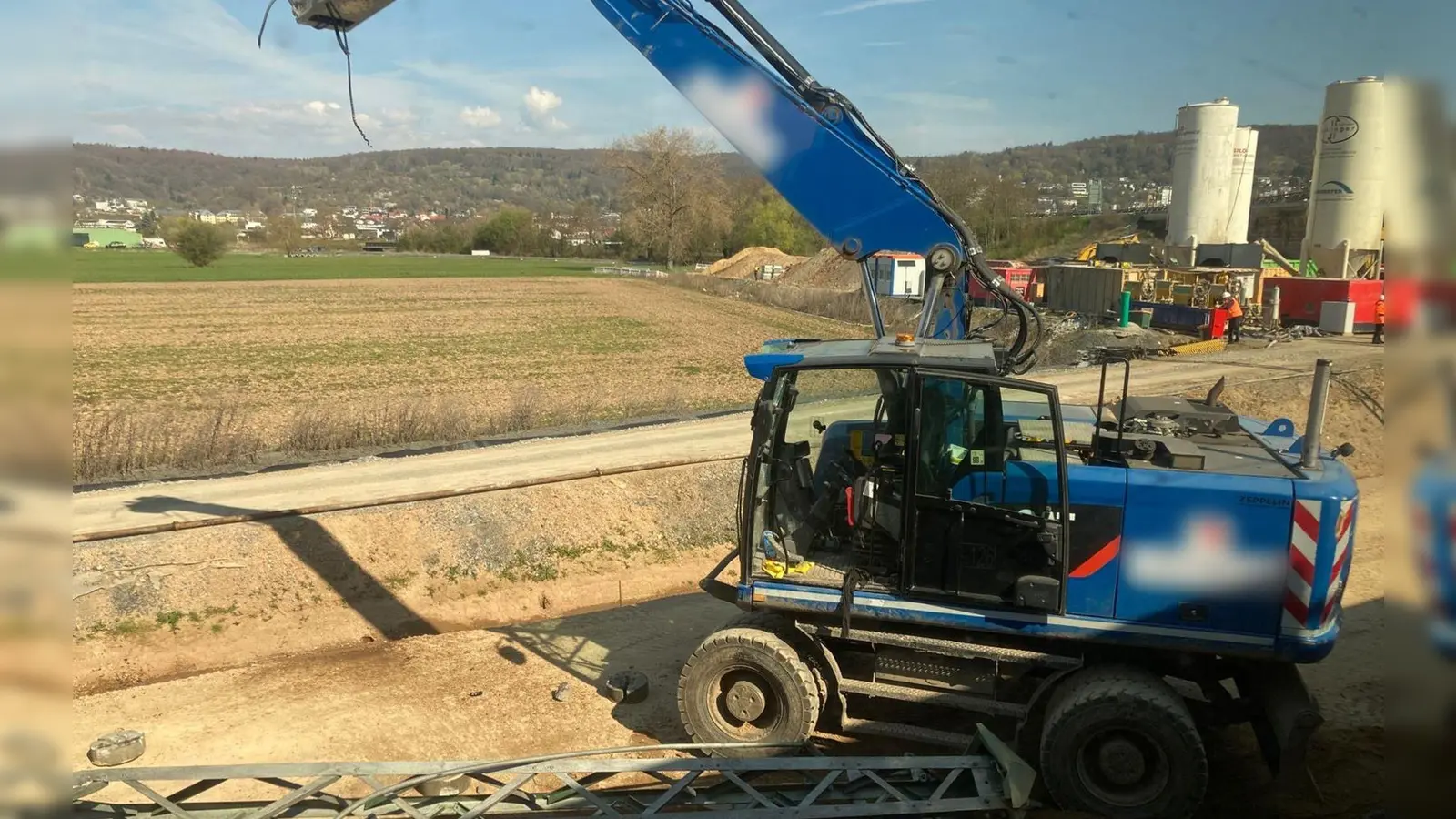Der beschädigte Bagger steht an einer Baustelle neben den Bahngleisen. (Foto: Privat/dpa)