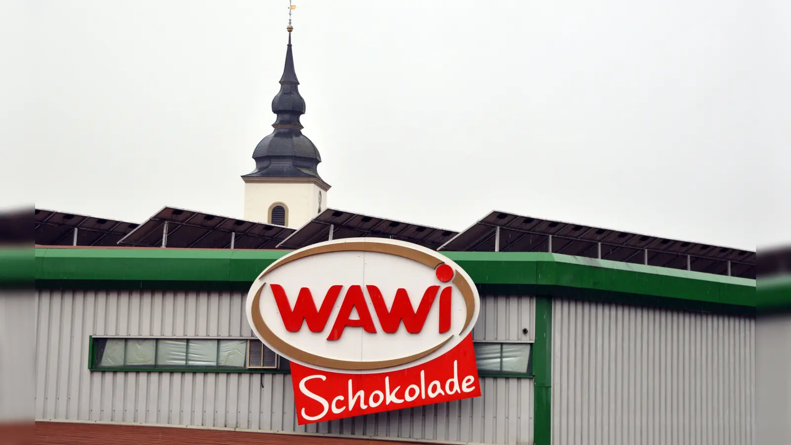 Schokoladenfabrik mit Ortswahrzeichen im Hintergrund: Die Wawi-Gruppe will den Standort in Burghaslach stärken und womöglich sogar weiter ausbauen. (Foto: Johannes Zimmermann)