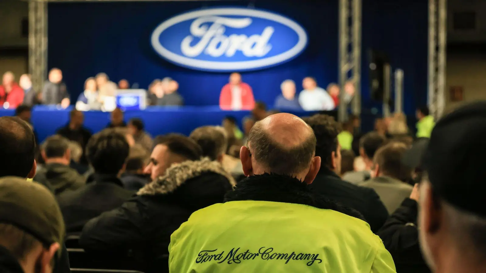 Ford-Mitarbeiter warten auf den Beginn der Betriebsversammlung. (Foto: Oliver Berg/dpa)