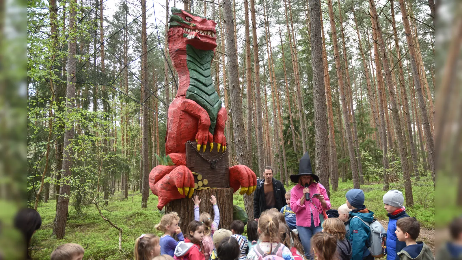 Der Drache und seine Schöpfer: Autorin Miriam Mendl-Möhring (mit schwarzem Hexenhut) und der Künstler Reinhard Bader. Die Kinder hatten ihre Freude daran. (Foto: Anita Dlugoß)