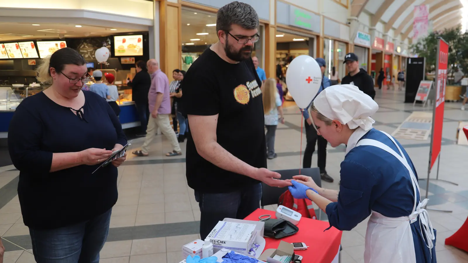 Ein kleiner Pieks, um den Blutzucker zu testen: Saskia Soukop (in historischer Schwesterntracht) kümmert sich um Freiwillige. (Foto: Oliver Herbst)