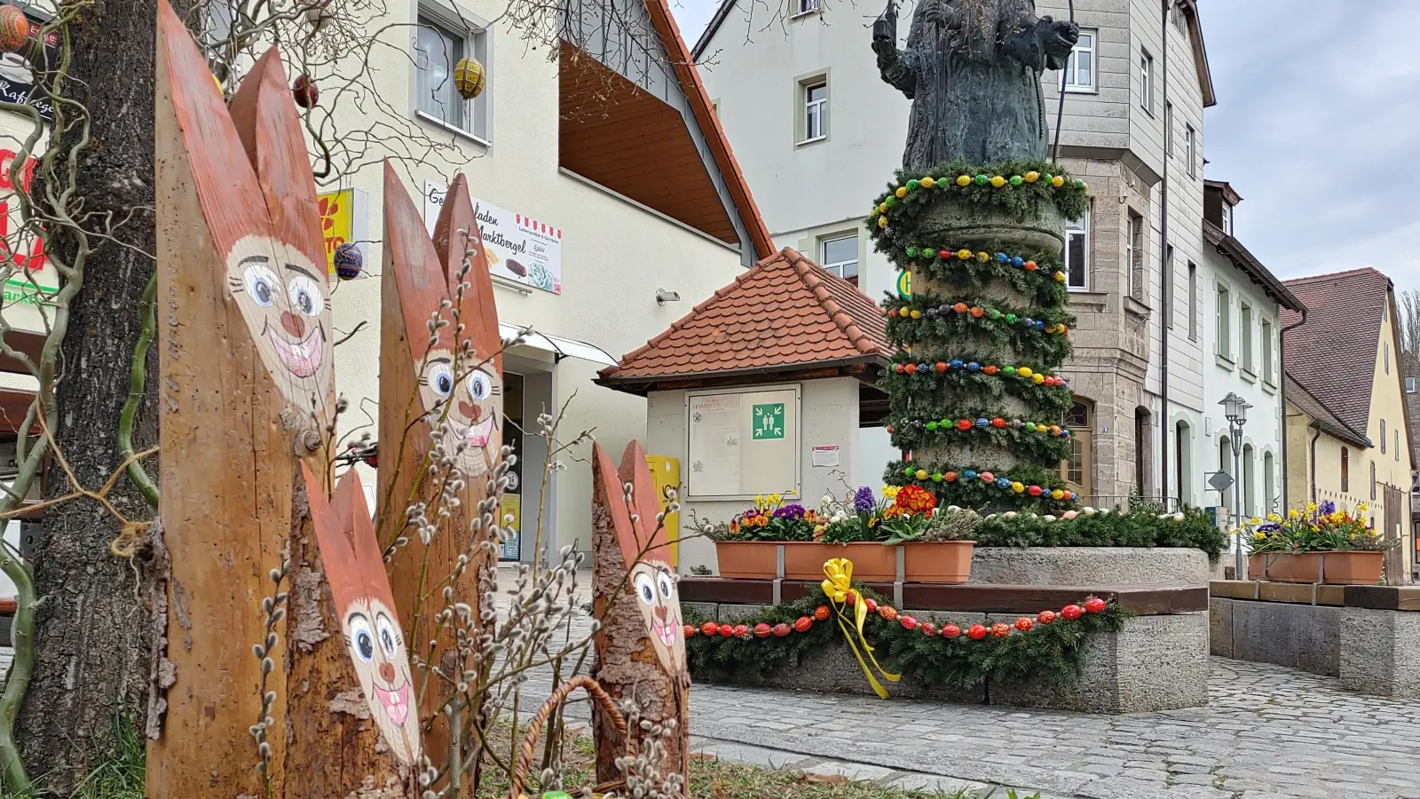 Eine Osterhasenfamilie aus Holz bewacht seit jeher den Osterbrunnen in Marktbergel. (Foto: Katrin Merklein)