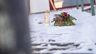 Vor dem Firmengebäude, in dem die Leichen der beiden Söhne gefunden wurden, liegen eine Kerze und ein Kranz. (Foto: Jason Tschepljakow/dpa)