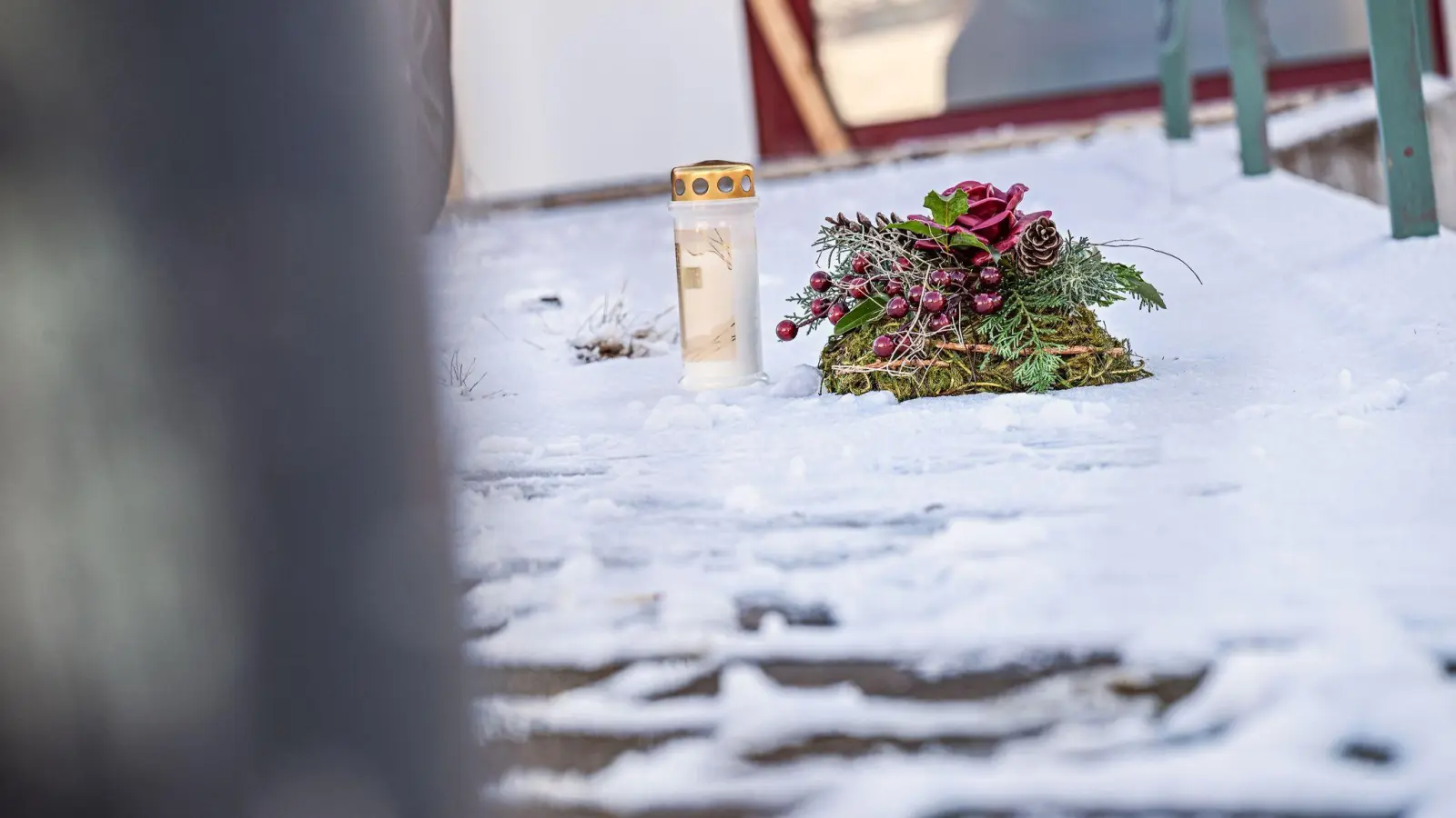 Vor dem Firmengebäude, in dem die Leichen der beiden Söhne gefunden wurden, liegen eine Kerze und ein Kranz. (Foto: Jason Tschepljakow/dpa)