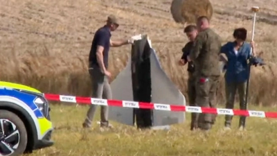 Einsatzkräfte von Polizei und Militärpolizei sichern Teile einer beschädigten Drohne. (Foto: Rafal Niedzielski/AP/dpa)