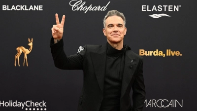 Robbie Williams erhält einen Bambi.  (Foto: Felix Hörhager/dpa)