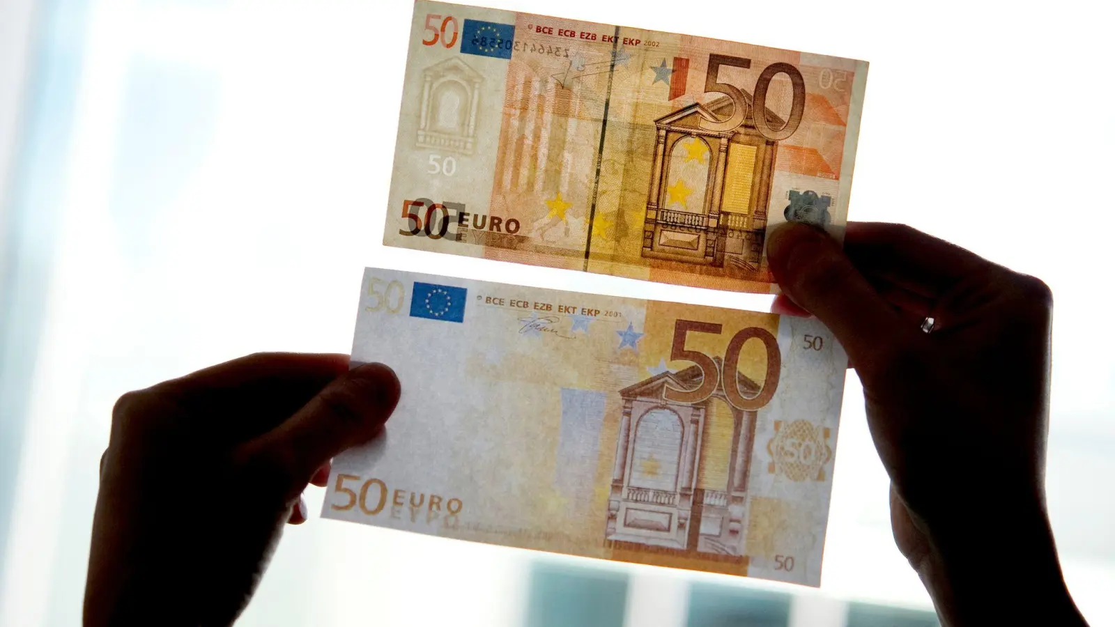 Falsche Größe, fehlende Sicherheitsmerkmale, schlechte Farbgebung: Ein gefälschter Euro-Schein (unten) ist nicht immer so leicht vom Original zu unterscheiden. (Foto: Franziska Gabbert/dpa-Zentralbild/dpa)