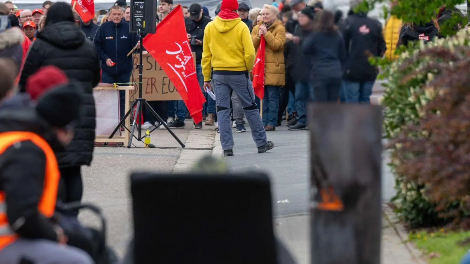 Streikende Mitarbeiter sitzen vor dem Werksgelände der Firma Schwabmüller. (Foto: Armin Weigel/dpa)