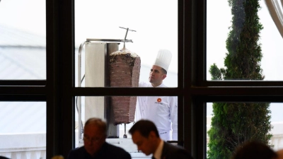 Ein Koch bereitet auf einer Terrasse des Präsidialpalasts Dönerfleisch vom Spieß zu. (Foto: Bernd von Jutrczenka/dpa)