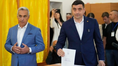 Der rechte Präsidentschaftskandidat George Simion (r) hat die absolute Mehrheit verpasst und muss am 18. Mai in eine Stichwahl. (Foto: Vadim Ghirda/AP/dpa)