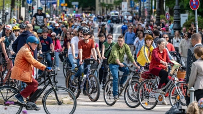 Auf Fahrrädern ziehen Hunderte Menschen durch München. (Foto: Armin Weigel/dpa)