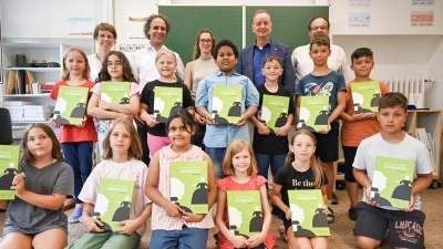Kulturreferentin Nadja Wilhelm, Dr. Michael Reinhart von der Sparkasse, Autorin Larissa Ulrich, Oberbürgermeister Thomas Deffner und Roberto Eichinger von der Hilterhaus-Stiftung übergaben das Buch an Schülerinnen und Schüler der Friedrich-Güll-Schule. (Foto: Stadt Ansbach / Stefan Guggenberger)