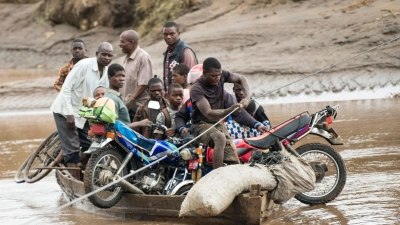 Nach dem Zyklon transportieren Männer in Malawi ihre geretteten Habseligkeiten mit einem Holzboot. (Foto: Thoko Chikondi/AP)