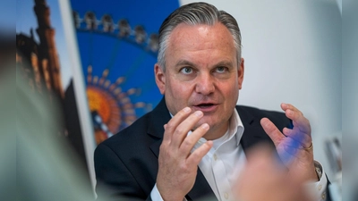 Münches neuer Wiesnchef Scharpf vor einem Foto des Riesenrades.  (Foto: Peter Kneffel/dpa)